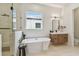 Bright bathroom featuring a standalone tub, glass-enclosed shower, and modern vanity with a white countertop at 7974 1St S Ave, St Petersburg, FL 33707
