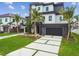 Striking contemporary home with a dark gray garage, perfectly manicured lawn, and lush palm trees at 7974 1St S Ave, St Petersburg, FL 33707