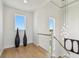 Hallway with light hardwood floors, modern railings, bright lighting, and beautiful decorative touches at 7974 1St S Ave, St Petersburg, FL 33707