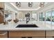 Close up of a kitchen island with stone countertop, a sink, and an open layout to the Gathering room at 7974 1St S Ave, St Petersburg, FL 33707
