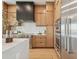 Bright kitchen featuring light wood cabinets, stainless steel appliances, and a stylish black range hood at 7974 1St S Ave, St Petersburg, FL 33707