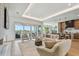Bright living room featuring modern furniture, stone fireplace, TV, and sliding glass doors with water views at 7974 1St S Ave, St Petersburg, FL 33707