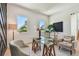 Home office with glass desk, neutral seating, and windows overlooking tropical landscaping at 7974 1St S Ave, St Petersburg, FL 33707