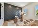 Bright and stylish home office with gray accent wall, contemporary glass desk, and comfortable seating at 7974 1St S Ave, St Petersburg, FL 33707