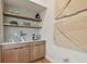 Contemporary wet bar with floating shelves, modern art, and wood cabinets at 7974 1St S Ave, St Petersburg, FL 33707