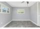 Bedroom featuring neutral gray walls, tile flooring, and windows with white shutters at 8515 Merrimoor Blvd, Seminole, FL 33777