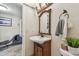 Traditional bathroom vanity with natural wood finish, decorative mirror, and textured walls at 854 Harbor Is, Clearwater, FL 33767