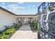Inviting entryway with brick pavers, lush plants, and a decorative wrought-iron gate creating a welcoming first impression at 854 Harbor Is, Clearwater, FL 33767