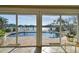 Pool view from inside the house, featuring a pool, waterfront, patio, and clear glass doors at 854 Harbor Is, Clearwater, FL 33767