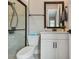 Modern bathroom featuring a sleek vanity, framed mirror, toilet, and tiled shower with a glass door at 8960 Windlass Cv, Parrish, FL 34219