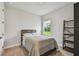 Neutral bedroom with a comfortable bed, window view, and a decorative bookshelf for storage at 8960 Windlass Cv, Parrish, FL 34219