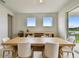 Well-lit dining room with large table and chairs next to sliding glass door to backyard at 8960 Windlass Cv, Parrish, FL 34219