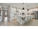 Bright, modern kitchen features an island with seating, stainless steel appliances, and white cabinetry at 8960 Windlass Cv, Parrish, FL 34219