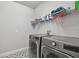 Functional laundry room with modern washer and dryer units and shelving for storage at 8960 Windlass Cv, Parrish, FL 34219