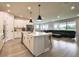 Spacious open concept living space featuring kitchen island, stainless appliances and leather sofa at 8960 Windlass Cv, Parrish, FL 34219