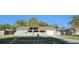 Well-kept single-story house featuring a lush lawn, mature trees, and attached garage at 1007 Greenleaf Way, Tarpon Springs, FL 34689
