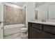 Well-lit bathroom featuring a shower-tub combo with tile surround, vanity with sink, and modern fixtures at 10520 Hidden Banks Gln, Parrish, FL 34219