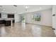 Open living room showcasing ceramic tile floors and ample natural light from windows and sliding glass door at 10520 Hidden Banks Gln, Parrish, FL 34219
