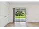 Bright room with sliding glass doors leading to an outdoor patio with lush green backyard views at 10520 Hidden Banks Gln, Parrish, FL 34219
