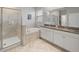 Bright bathroom featuring double granite sinks, a soaking tub, and a glass enclosed shower, offering spa-like amenities at 10628 Bahama Woodstar Ct, Riverview, FL 33579