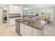 Modern kitchen island with double sink, sleek appliances, and views to the living room at 10628 Bahama Woodstar Ct, Riverview, FL 33579