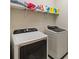 Modern laundry room with front loading machines and a storage shelf at 10628 Bahama Woodstar Ct, Riverview, FL 33579