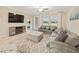 Cozy living room with a comfortable gray sofa, modern decor, and views of the lake at 10628 Bahama Woodstar Ct, Riverview, FL 33579
