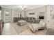 Spacious living room with tile floors, gray sofas, patterned rug, and a large mirror, perfect for entertaining at 10628 Bahama Woodstar Ct, Riverview, FL 33579