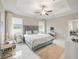 Spacious main bedroom featuring a tray ceiling, neutral colors, two windows and marble tile flooring at 10628 Bahama Woodstar Ct, Riverview, FL 33579