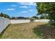 Spacious backyard featuring a white fence, mature trees, and a clear blue sky at 11136 Hartford Fern Dr, Riverview, FL 33569