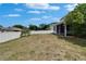 Large backyard with a white fence, partial view of screened-in porch and green lawn at 11136 Hartford Fern Dr, Riverview, FL 33569