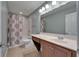 Bathroom with a shower-tub combo and a single vanity with light sconces at 11136 Hartford Fern Dr, Riverview, FL 33569