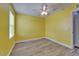 Empty bedroom with wood floors, yellow walls, and a bright ceiling fan at 11136 Hartford Fern Dr, Riverview, FL 33569