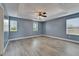 Spacious bedroom featuring light gray walls and floors, with a tray ceiling and three large windows at 11136 Hartford Fern Dr, Riverview, FL 33569