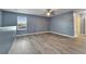 Spacious living area featuring wood floors, a ceiling fan, and plenty of natural light from a large window at 11136 Hartford Fern Dr, Riverview, FL 33569