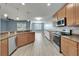 Open-concept kitchen boasts granite counters, stainless steel appliances, wood cabinets, and mosaic backsplash, open to dining and living spaces at 11136 Hartford Fern Dr, Riverview, FL 33569