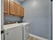 Convenient laundry room with modern washer and dryer and ample cabinet space above at 11136 Hartford Fern Dr, Riverview, FL 33569