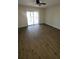 Bright living room featuring wood-look flooring, a ceiling fan, and sliding doors to the balcony at 11411 Pike Ct # 6, New Port Richey, FL 34654