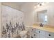 Cozy bathroom featuring a shower with decorative curtain, white vanity, and neutral tones at 11607 Meridian Point Dr, Tampa, FL 33626