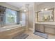 Bathroom featuring a soaking tub, shower, vanity, and large window at 11607 Meridian Point Dr, Tampa, FL 33626
