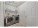 Functional laundry room with modern washer and dryer, storage shelf, and bright lighting at 11607 Meridian Point Dr, Tampa, FL 33626