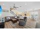 Open-concept living room with a plush sectional sofa, ceiling fan, and view of the kitchen and stairs at 11607 Meridian Point Dr, Tampa, FL 33626