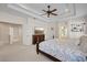 Spacious main bedroom featuring tray ceiling, large bed, and an ensuite bathroom at 11607 Meridian Point Dr, Tampa, FL 33626