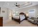 Serene main bedroom with tray ceiling, neutral decor, and a glimpse into the ensuite bathroom at 11607 Meridian Point Dr, Tampa, FL 33626