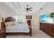 Spacious primary bedroom suite featuring a tray ceiling, ceiling fan, and hardwood furniture at 11607 Meridian Point Dr, Tampa, FL 33626