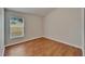 Clean bedroom featuring neutral paint, wood floors, a window with blinds, and white trim at 11626 Pure Pebble Dr, Riverview, FL 33569
