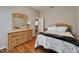 Bedroom with wood floors, classic dresser and mirror combo, and tranquil ambiance at 11626 Pure Pebble Dr, Riverview, FL 33569