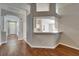 Open-concept entryway with wood floors, neutral walls, arched doorways, and a pass-through to a bright kitchen at 11626 Pure Pebble Dr, Riverview, FL 33569