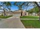 Inviting single-Gathering home featuring a lush front lawn, driveway, and a charming exterior design at 11626 Pure Pebble Dr, Riverview, FL 33569