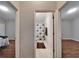 Hallway view to a full bathroom in between two bedrooms, with hardwood floors and neutral walls at 11626 Pure Pebble Dr, Riverview, FL 33569